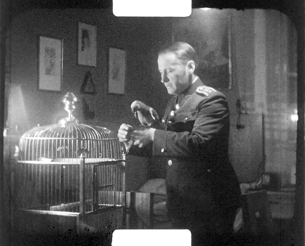 Pan podplukovník s papouškem. Jak je zřejmé, experimentoval i s natáčením při umělém osvětlení. Zdroj: Sbírka Rakouského filmového muzea